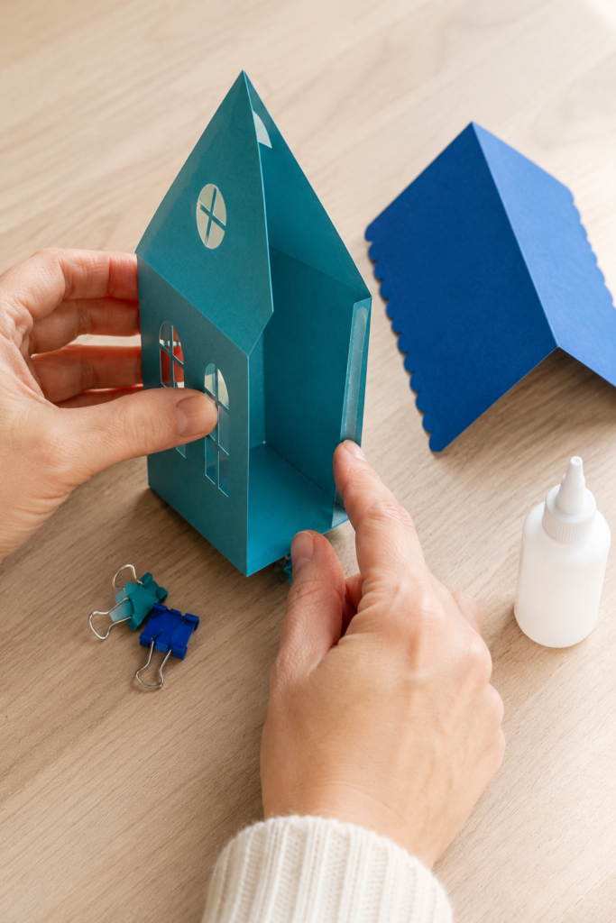 Assembling an open-backed turquoise Christmas house