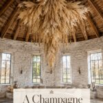 Refined Thanksgiving barn with cascading ivory harvest chandelier pale pumpkins and aged silver vessels