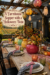 Farmhouse Halloween supper title above a harvest table with colorful kettles pumpkins pears and checked place settings