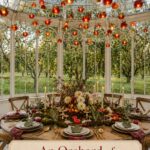Fall greenhouse tablescape beneath glowing apple lanterns with an orchard centerpiece and a warm editorial title panel