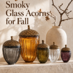 smoky glass acorns for fall displayed with oak branches and a cream pottery vase