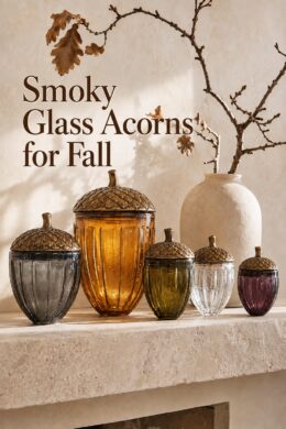 smoky glass acorns for fall displayed with oak branches and a cream pottery vase