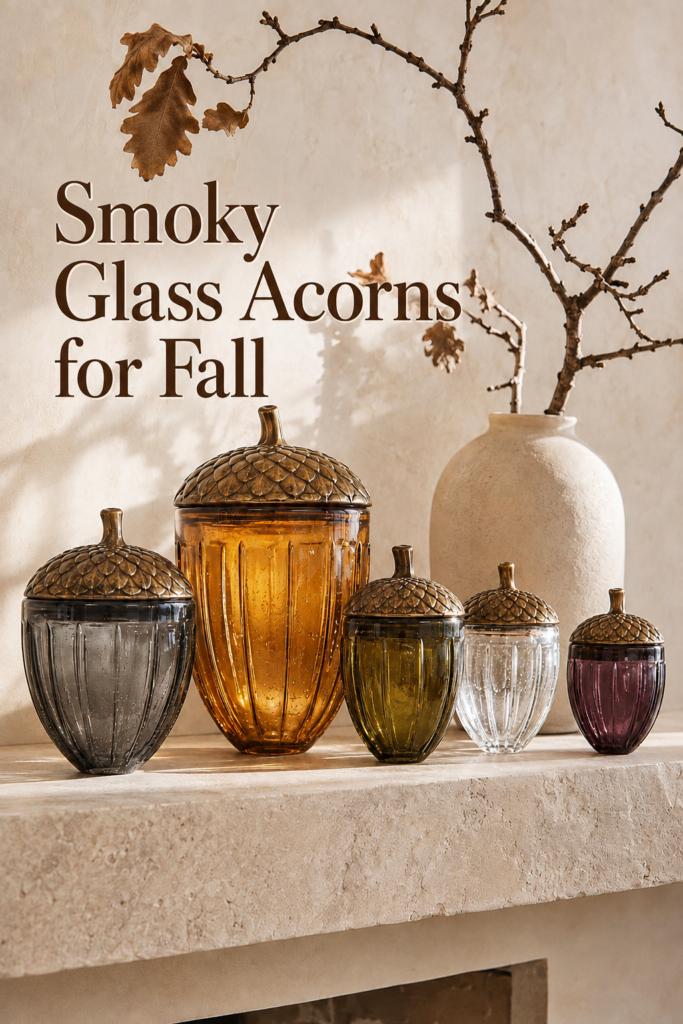 smoky glass acorns for fall displayed with oak branches and a cream pottery vase