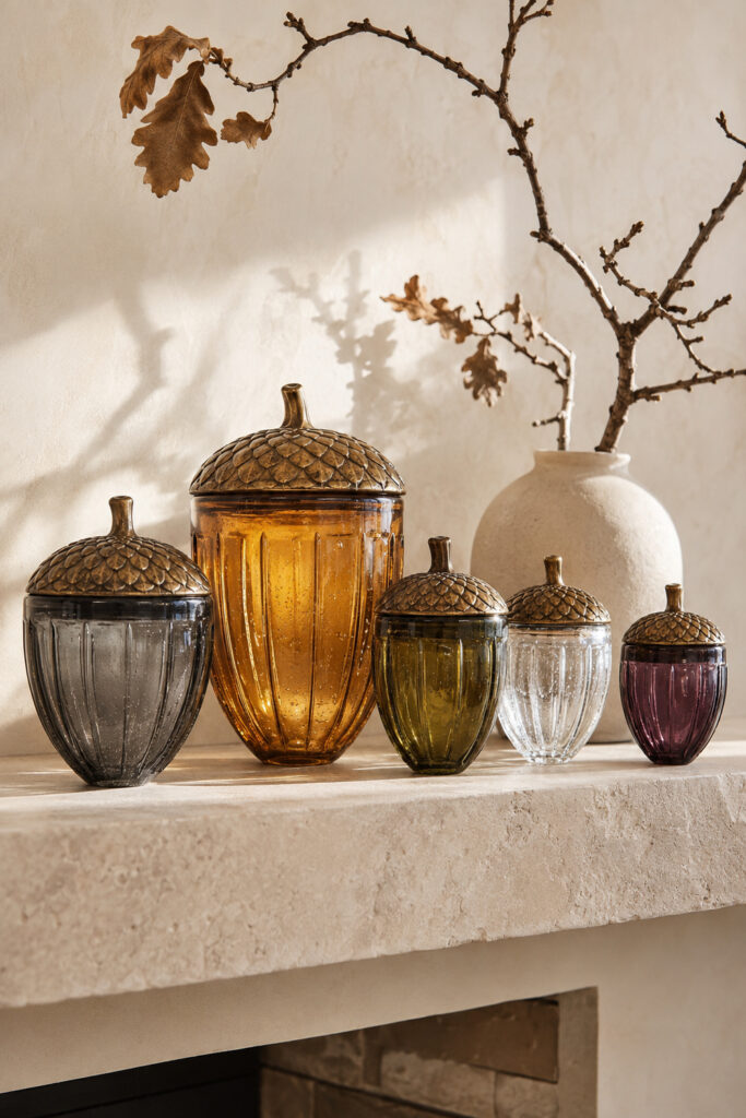 smoky glass acorn collection in amber olive charcoal clear and plum on a limestone fall shelf