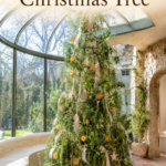 Garden inspired Christmas tree with trailing greenery citrus ornaments and cream ribbon beneath text reading A Garden Inspired Christmas Tree