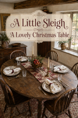 Cottage Christmas dining table with mixed patterned dishes and a sleigh centerpiece beneath text reading A Little Sleigh A Lovely Christmas Table