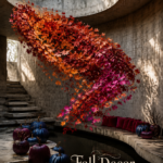 Fall leaf installation above a curved courtyard bench with jewel toned pumpkins and ivory text reading Fall Decor with a Dramatic Twist