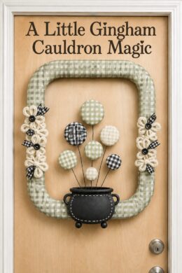 Rectangular gingham cauldron wreath with checked bubbles and button centered flowers beneath the words A Little Gingham Cauldron Magic