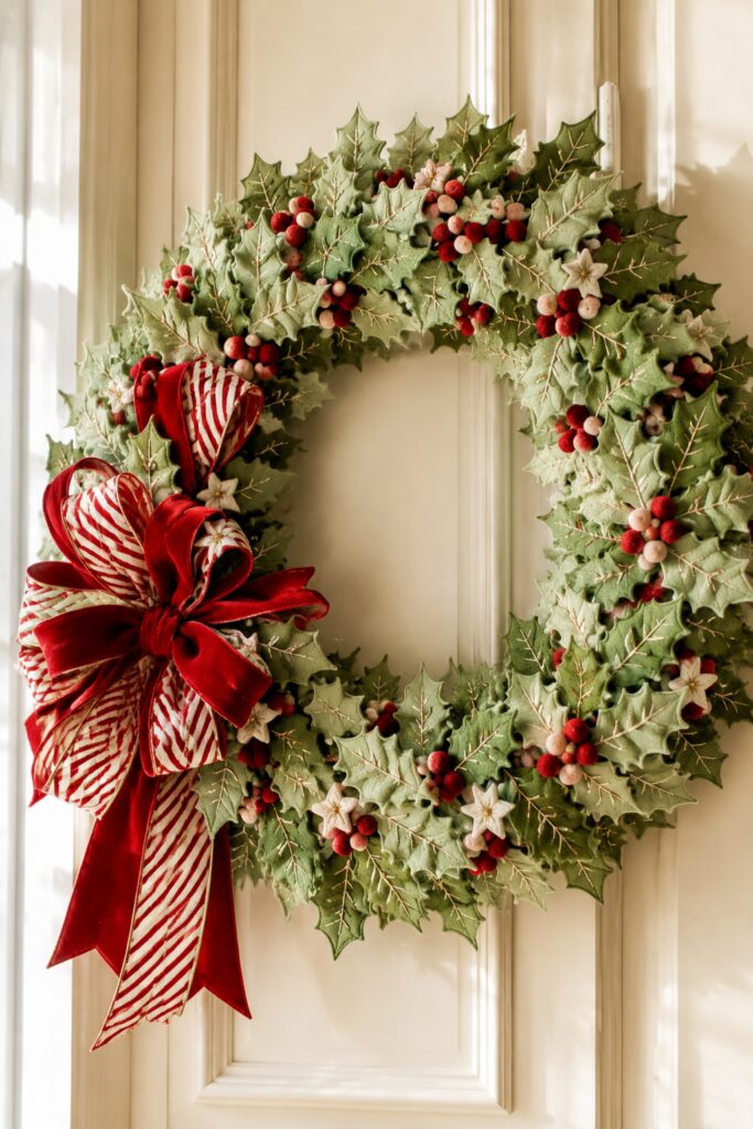 green holly felt wreath with red and white berries and red and white striped bow