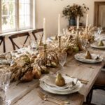 Harvest table with gold flatware and clear stemware beneath text reading Pears and Wheat A Thanksgiving Table to Gather Around