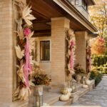 Prairie style covered entry with pink ribbon harvest swags and ivory pumpkins with text reading A Pink Ribbon Fall Welcome