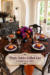 Purple dahlia Halloween table with black lace layers white tapers and a headline about the floral table setting