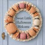 Ruffled cream wreath framing the words Sweet Little Halloween Welcome with oversized checked fabric candies on a blue paneled door