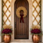 Wheat lattice Thanksgiving entry framed by burgundy mums olive foliage and copper planters