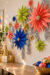 old Your Own Christmas Stars text over colorful dimensional paper stars and silver tinsel on a pegboard craft wall